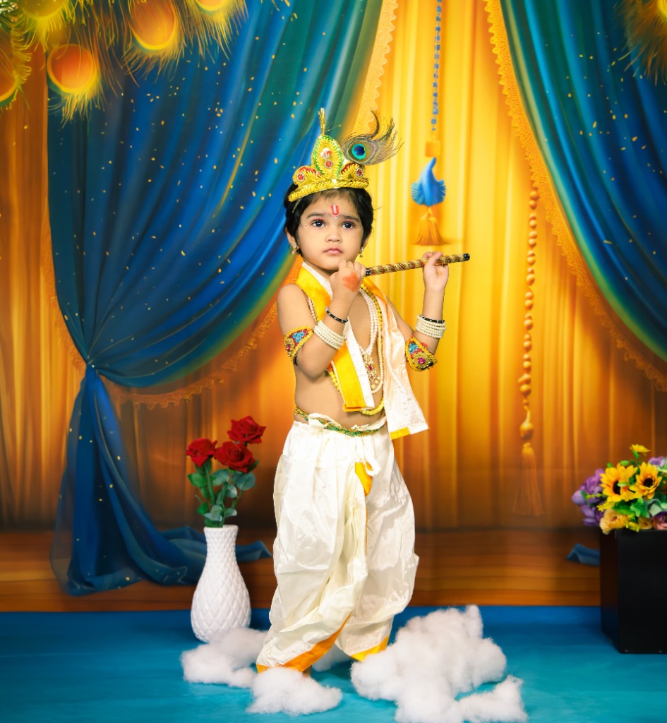 Baby dressed as Little Krishna with peacock feather crown, golden flute and silk dhoti